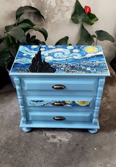 a blue chest with a painting on it