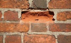 an old brick wall with small holes in it