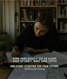 a woman sitting at a desk writing in front of a book shelf with books on it