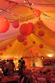 the inside of a marquee decorated with paper lanterns