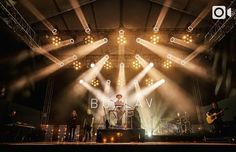 the band blaav is performing on stage with their guitars and lights behind them