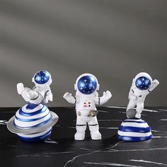 three toy astronauts standing next to each other