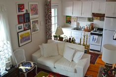 a living room filled with furniture and pictures on the wall