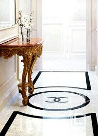 a table with flowers on top of it in the middle of a room next to a doorway