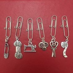 a bunch of different types of charms on a red leather surface with clippings