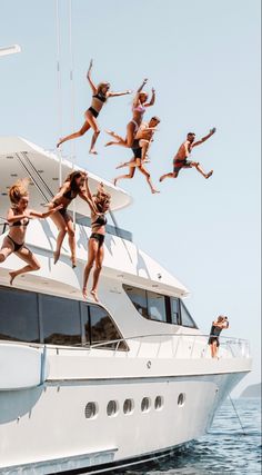 a group of people jumping off the back of a boat