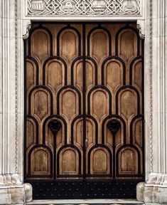 an ornate wooden door in front of a building