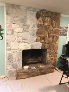 a stone fireplace in a living room next to a tv