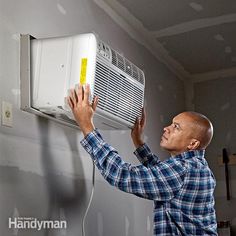 a man is working on an air conditioner