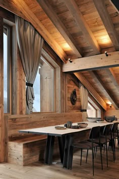 a dining room with wooden walls and flooring in an atticed building, overlooking the mountains