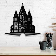 a white brick wall with a black silhouette of a church