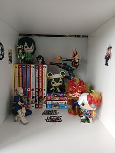 some anime figurines and books on a shelf