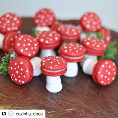 small red and white mushrooms sitting on top of a wooden table