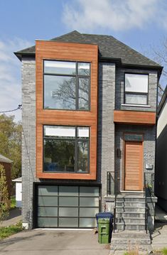 a two story house with wood and glass on the front