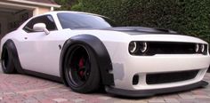 a white and black car parked in front of a house