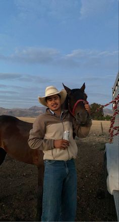 a man in cowboy hat holding up a horse