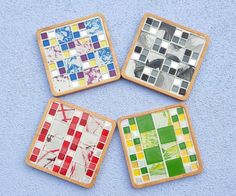 four coasters made out of wood with different colored tiles on them, sitting on a blue surface