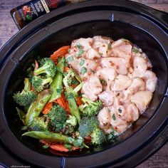 chicken, broccoli and carrots in a crock pot with seasoning