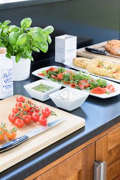 the kitchen counter is covered with fresh vegetables and ingredients for salads, including tomatoes