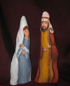 two nativity figurines, one holding a baby jesus