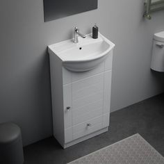 a white sink sitting next to a toilet in a bathroom on top of a rug