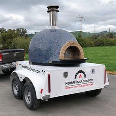 a white truck with a pizza oven on the back of it's flatbed