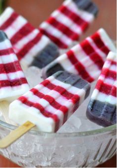 red, white and blue popsicles are in a glass bowl