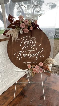 a wooden sign with flowers on it sitting in front of a glass window that says today is married