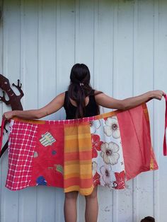 a woman is holding up her colorful towel