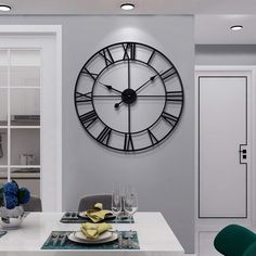 a large clock mounted to the side of a wall above a dining room table with place settings