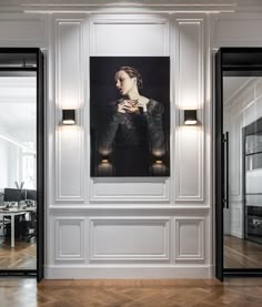 an empty room with white walls and wood flooring has a large painting on the wall