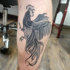 a black and white rooster tattoo on the leg