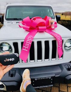 a jeep with a pink ribbon tied around it