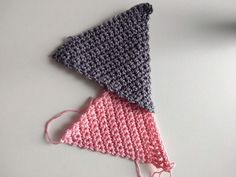 three crocheted triangulars sitting on top of each other, one pink and the other gray