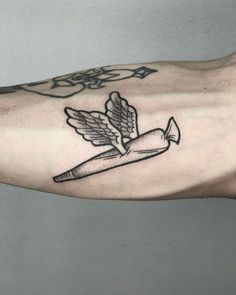 a person with a tattoo on their arm holding a pen and an angel wing above it