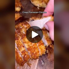 a person is cutting up some food on a wooden board with the words crispy parmesan chicken