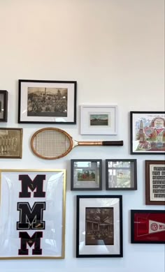 there are many framed pictures and tennis rackets on the wall