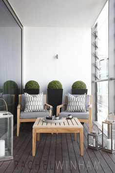 two wooden chairs sitting next to each other on top of a hard wood floored porch