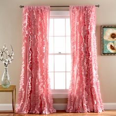 a pink curtain with ruffled edges in front of a window