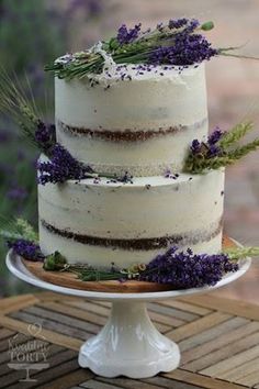 a three layer cake with lavender sprigs on top