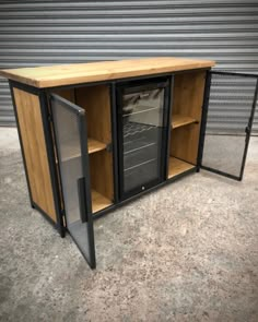 a wooden cabinet with metal doors and shelves on the outside, in front of a garage door