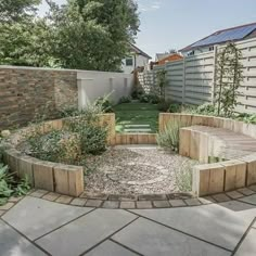 a circular garden area in the middle of a backyard with stone pavers and brick walls