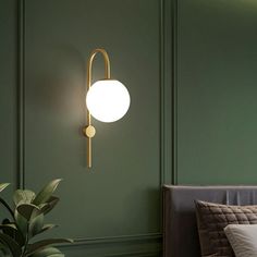 a bedroom with green walls and a white ball on the wall next to a bed