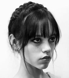 a black and white photo of a woman with her hair in a messy updo