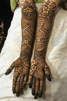 two hands with henna designs on them