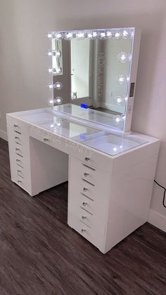 a white vanity with lighted drawers and mirror