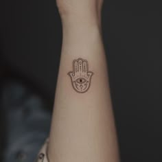 a small hamsa tattoo on the wrist