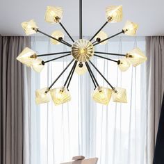 a modern chandelier hanging over a dining room table