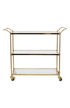 a gold metal and glass shelf on wheels