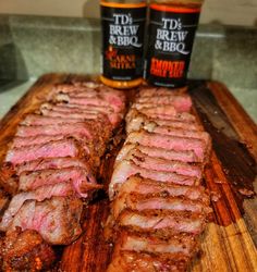 two bottles of beer sitting next to some meat